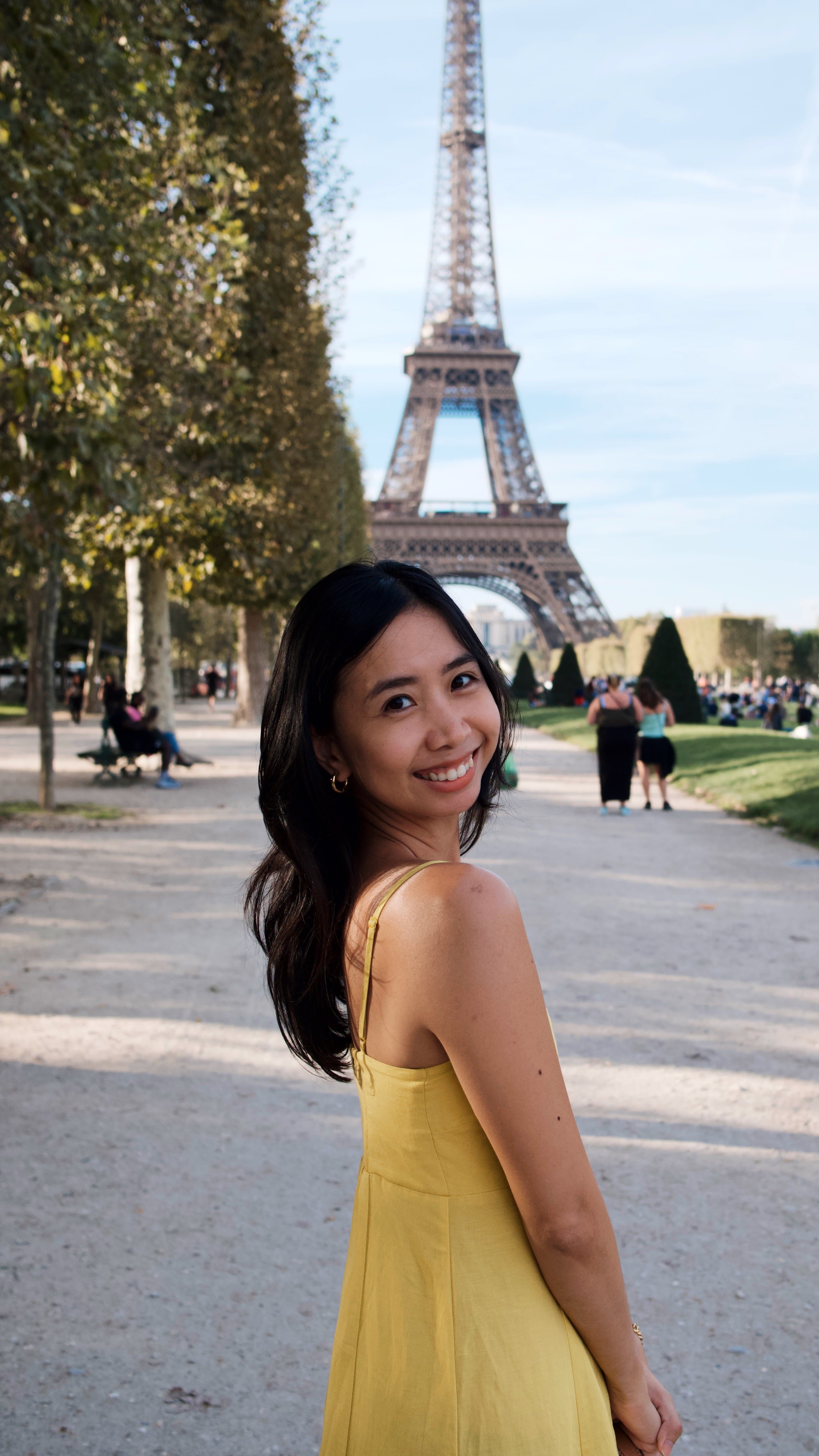 Trisha smiling in front of the Eiffel Tower in Paris